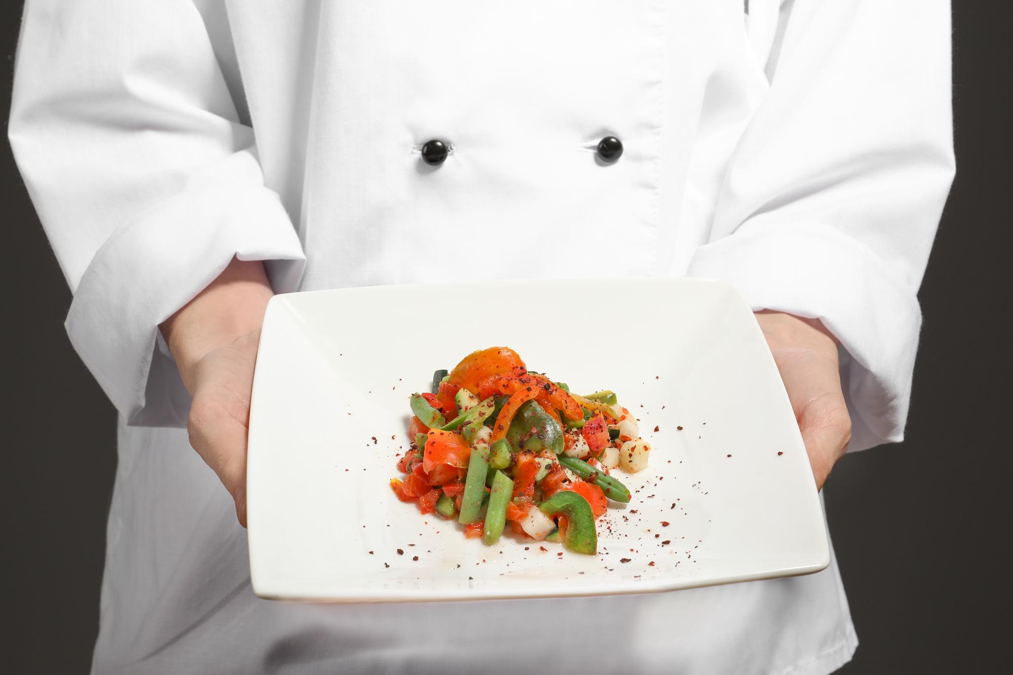 Chef preparando plato elegante en cocina moderna